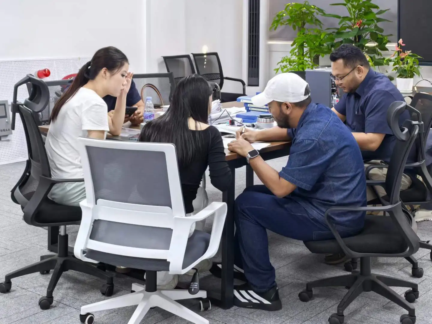 Engineering and sales teams discussing custom gas analyzer technical blueprints with clients in the conference room