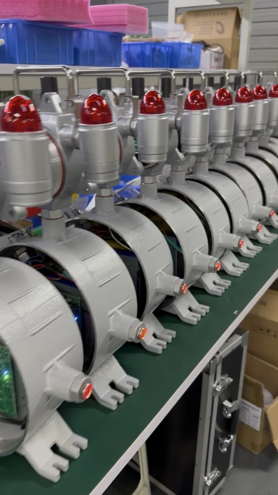 Row of open-cased HNAG1000 gas detectors undergoing power-on debugging at the factory