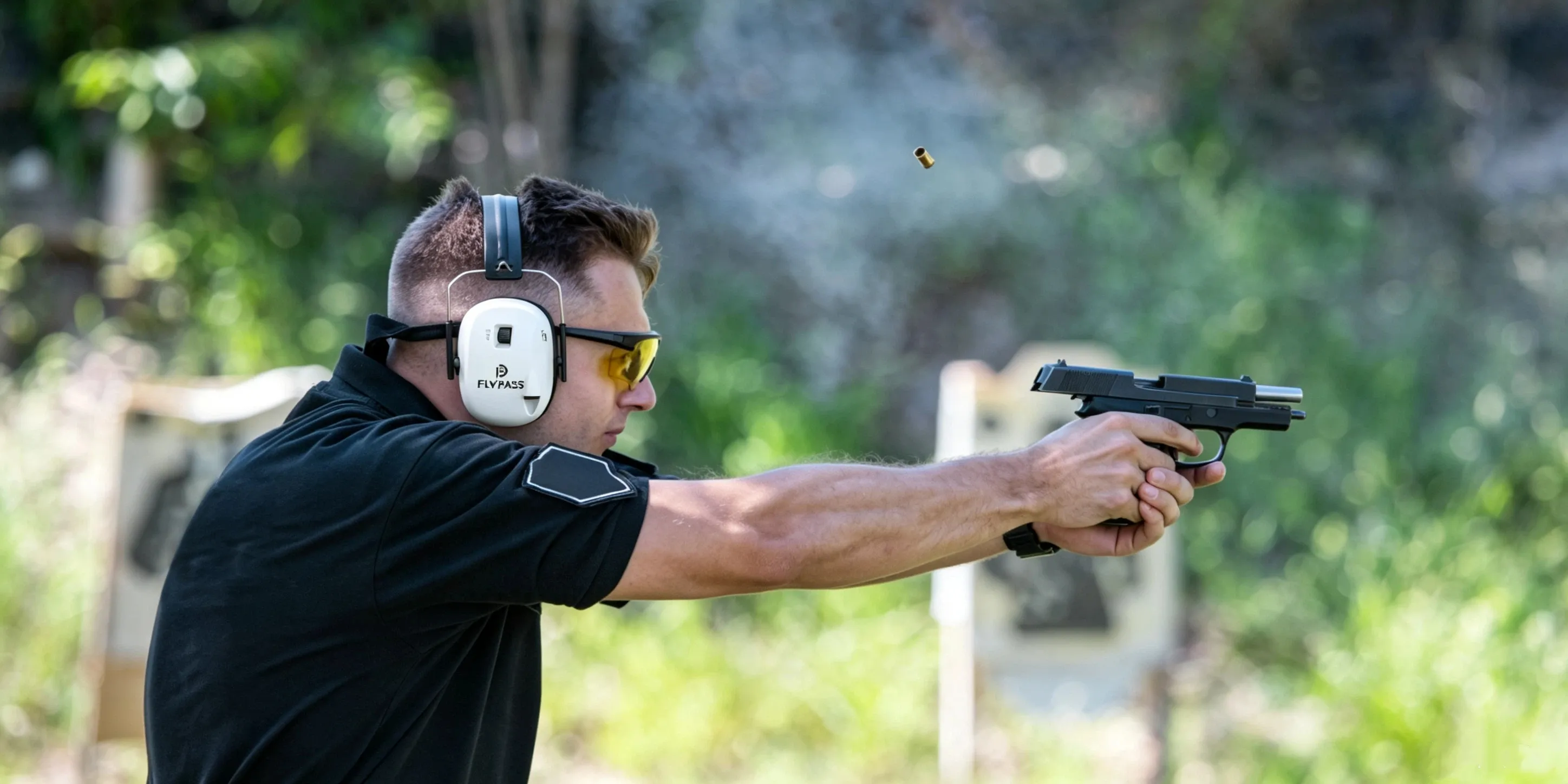 shooter wearing eye and ear protection at an outdoor gun range
